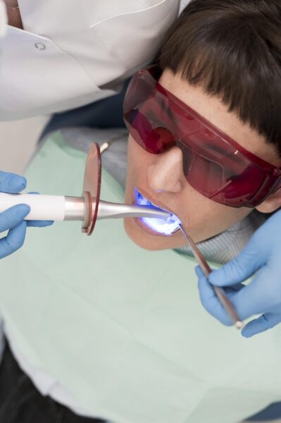 female patient having procedure done dentist scaled